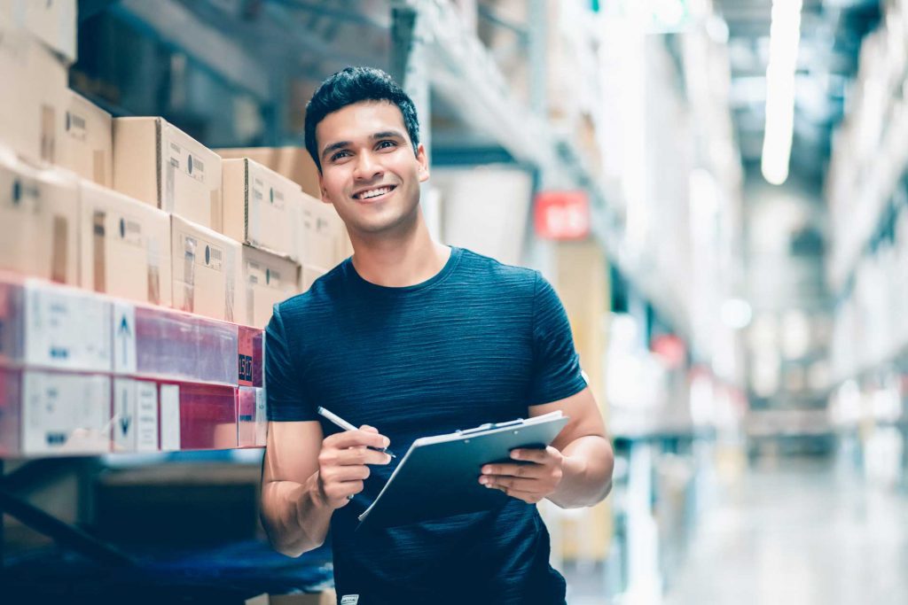 man in warehouse signing off packages